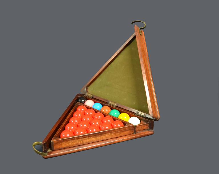 A mahogany cased triangular snooker ball cabinet with original triangle, manufactured by Burroughes & Watts of London, circa 1910, with a brass interlocking handle and original baize lined interior.

Complete with a full set of composite resin