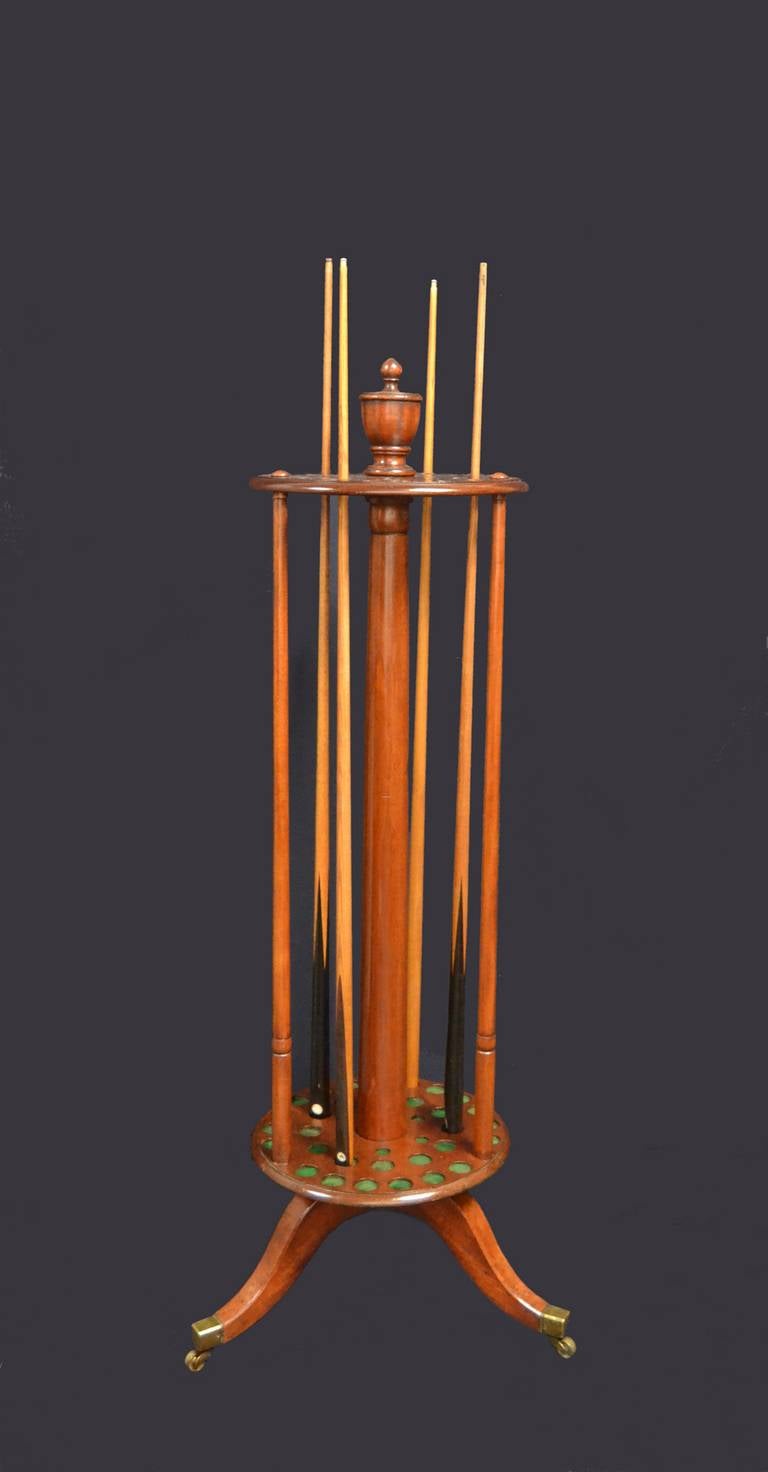 A mahogany revolving billiard cue stand of English Country House
proportions,  standing on three splayed feet with castors, supporting
 a turntable base with uprights columns beneath a pierced top for cue retention.

Capable of holding thirty