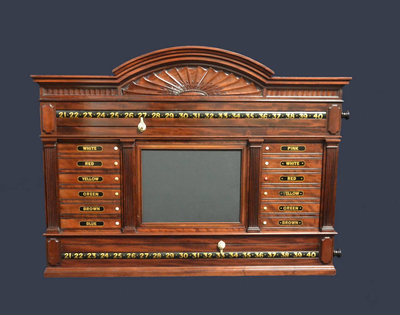 A wonderfully crafted Billiard- Snooker-pool  scoring cabinet in feathered mahogany probably by Burroughes & Watts of London, Circa 1900.

A decorative fan shaped carved pediment of linen fold relief above revolving number bars and lettered
