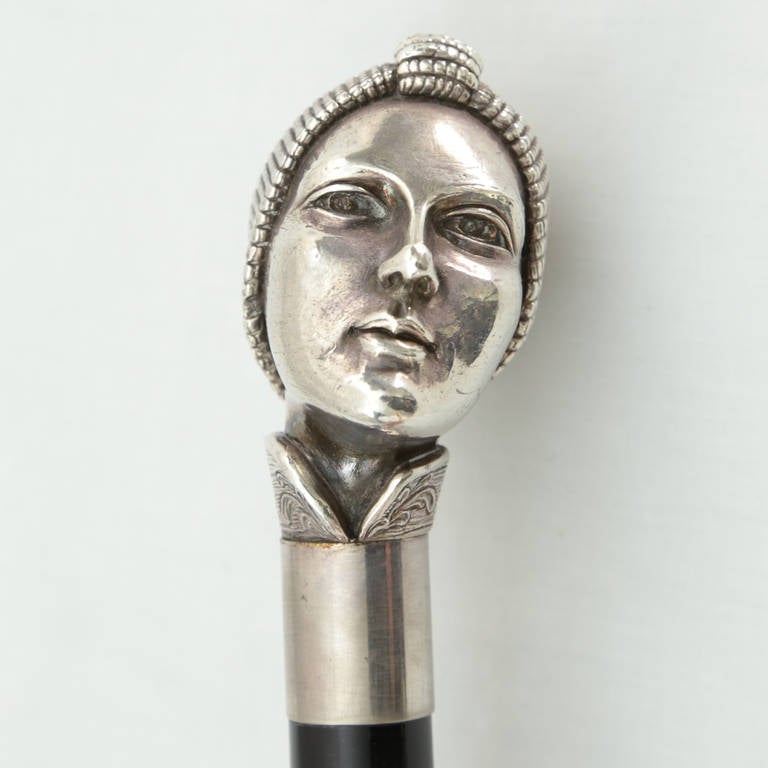 Beautiful Art Deco sculpted woman's head silver top handle and ebonized wood walking cane; brass tip. Approximate length: 36 inches. A perfect combination of style and functionality!