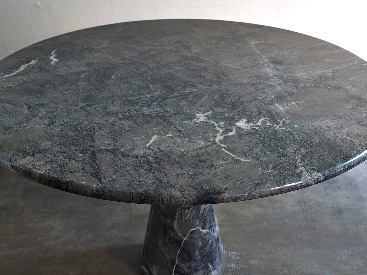 Large dining table by Angelo Mangiarotti in dark grey marble with beautiful black and white veins.

This iconic table clearly discloses the sculptural knowledge of Angelo Mangiarotti. Its minimalistic shapes are entirely made of 