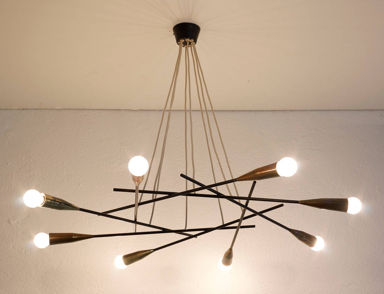 Impressive and very elegant chandelier attributed to Giampiero Aloi for Stilnovo, composed of eight black laquered metal and brass arms. Highly filigrane and aerial design.

Perfect condition.