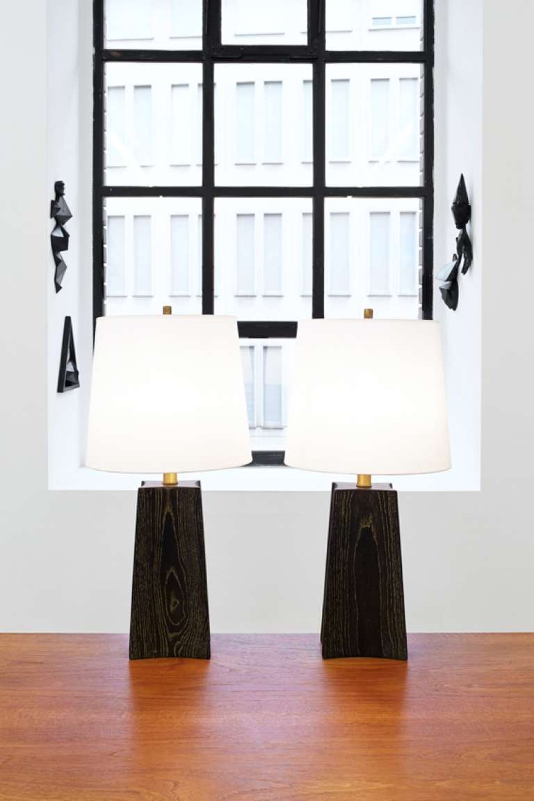 A pair of limed oak and bronze table lamps with raw silk shades.