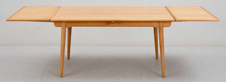 A dining table in oiled oak designed by Hans J. Wegner and made by cabinetmaker Andreas Tuck, in late 1950s. Model AT-312 with two extendible table leaves.