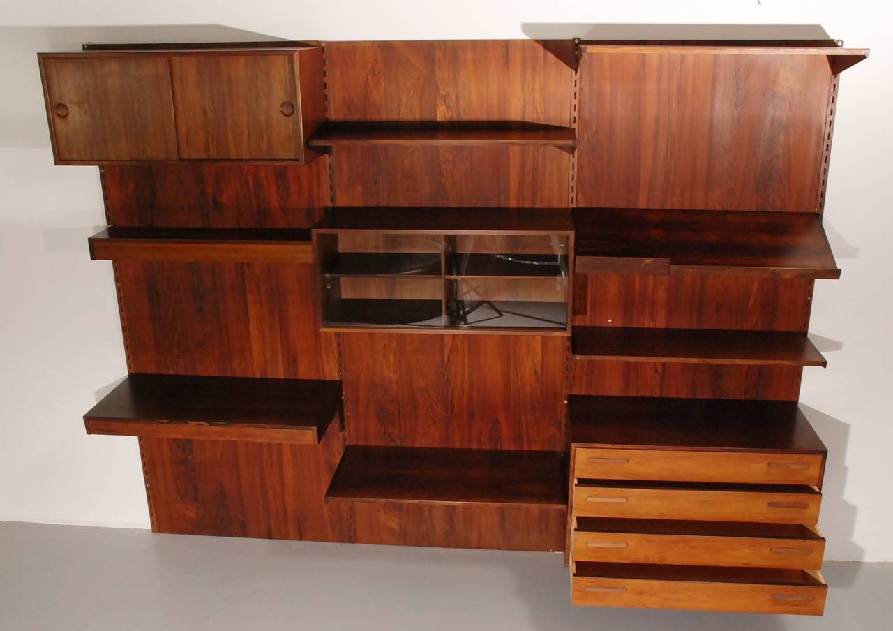 Beautiful wall system made in Denmark by FM. This is a very complete system with all types of cabinets, drawers, shelves and lecture shelve. There is even a light above the little desk. The condition is superb.  The price includes delivery to the US.