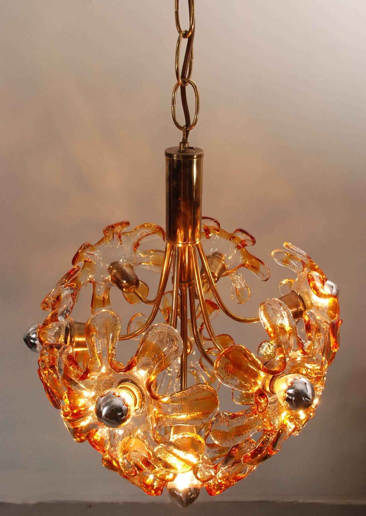 Beautiful and very rare chandelier of Mazzega with 11 big murano glass flowers. Suitable for 11 E14 bulbs, preferably silver-cupped lamps. The beautiful golden brown colour of the glass gives a very warm and friendly light. All glass flowers are in