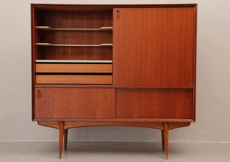 Very nice cabinet in teak with one big sliding door and two small sliding doors below. The bar section is made with water resistant shelves and two big drawers. It is in a very good condition with some minor scratches and marks.