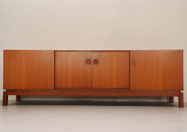 Very straight and solid cabinet/dressoir from the former Dutch manufacturer  Mahjongg. Construction of the doors is quite unusual as can be seen on the pictures. It looks like sliding doors...  One drawer behind a door. 

Some colour difference on