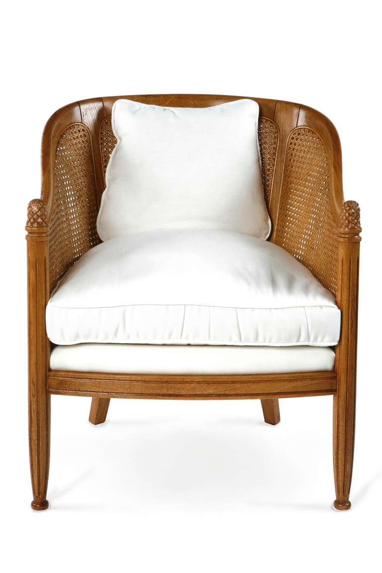The Bergère Tradition armchair is shown in Cherry wood with a Honeycomb finish. The Bergère Tradition is also known as gondola bergère and it has loose seat and back cushions. Note the caned sides and back and the fluted en carquois legs.