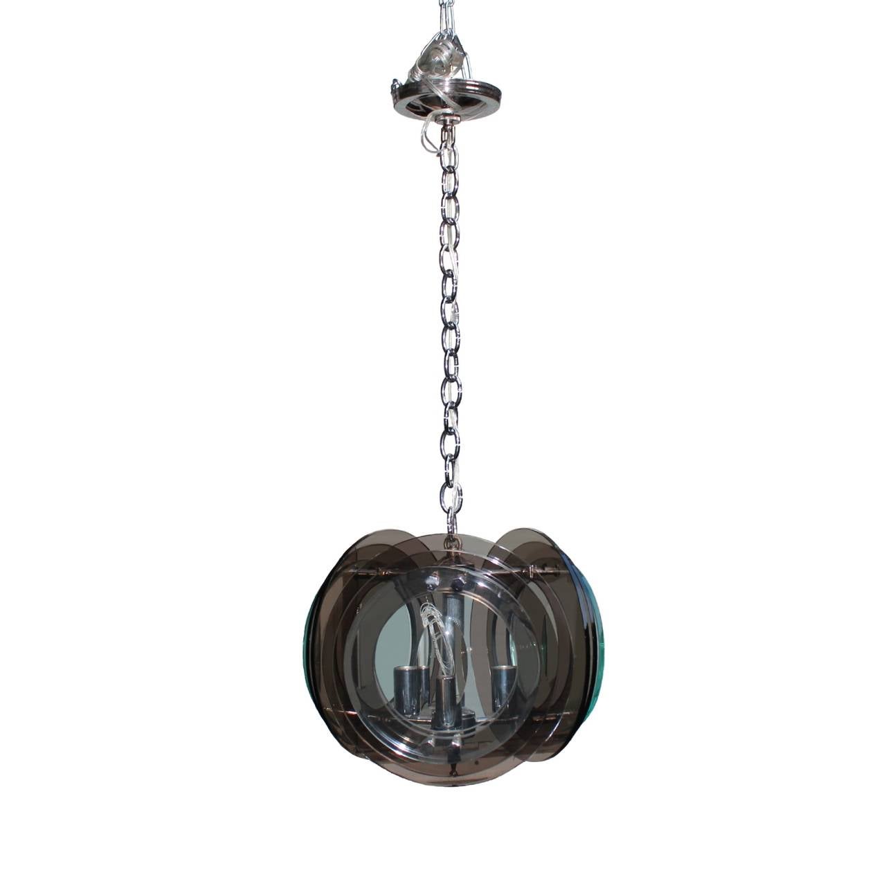 Pendant lamp of excellent quality having a central chrome baton with a drop finial supporting three sets of three glass discs corresponding in radius ascendance; smallest outer discs in light green glass with ellipsoid etchings, two larger discs in