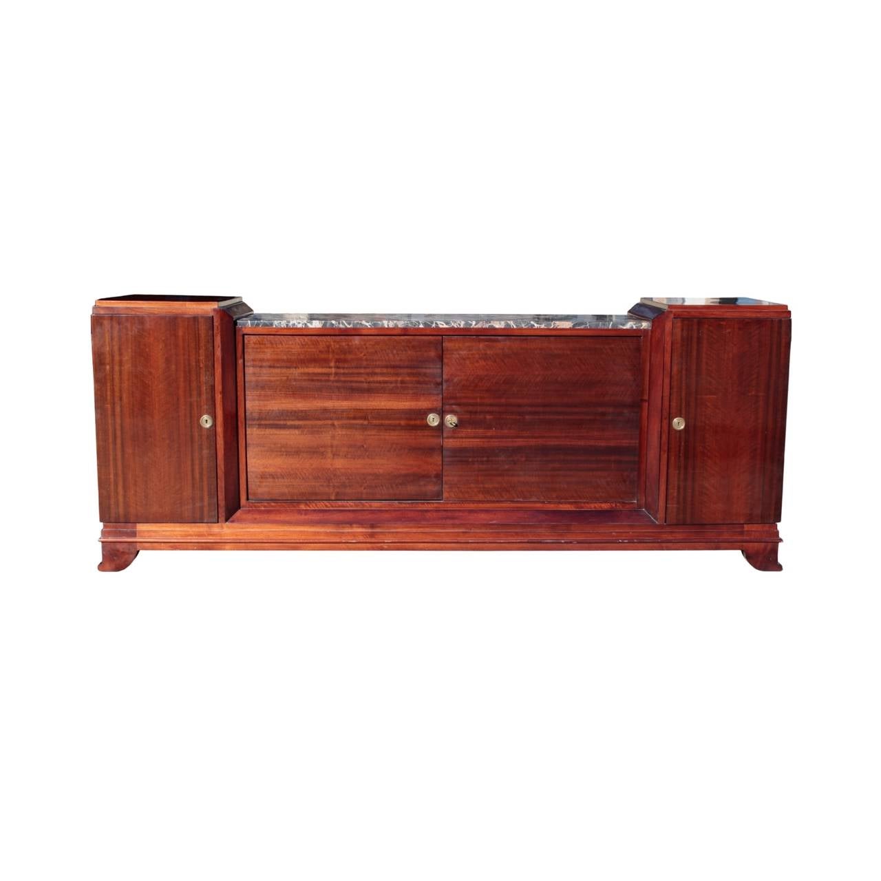 French Art Deco buffet of imposing volume and stark elegance. Recessed middle cabinet with two doors enclosing a single shelf and having a Negro Portoro marble top, flanked by a pair of taller side cabinets each with a single shelf interior. Four