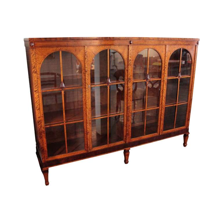 Excellent vitrine having two pairs of doors with arched glass fronts and crossed moldings decorated with carved anthemion leaves and 
