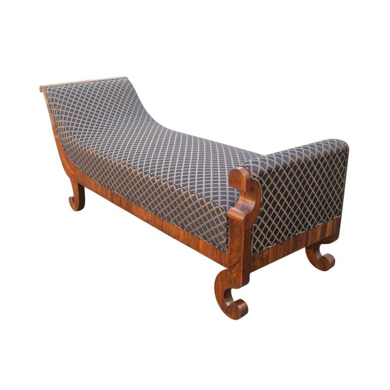 Rare and well proportioned daybed. Slanted headboard with elephant trunk shaped frame supports. Upholstered footboard decorated with a 