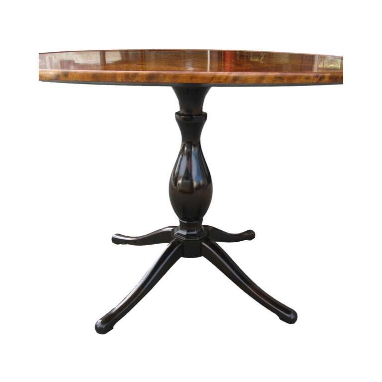 Elegant and gracious Swedish round center or small dining table with a removable (newly made) fitted glass top. Table top parquet veneered in flame birch with walnut banding. Stained birch urn pedestal resting on an octagonal disc and raised on four