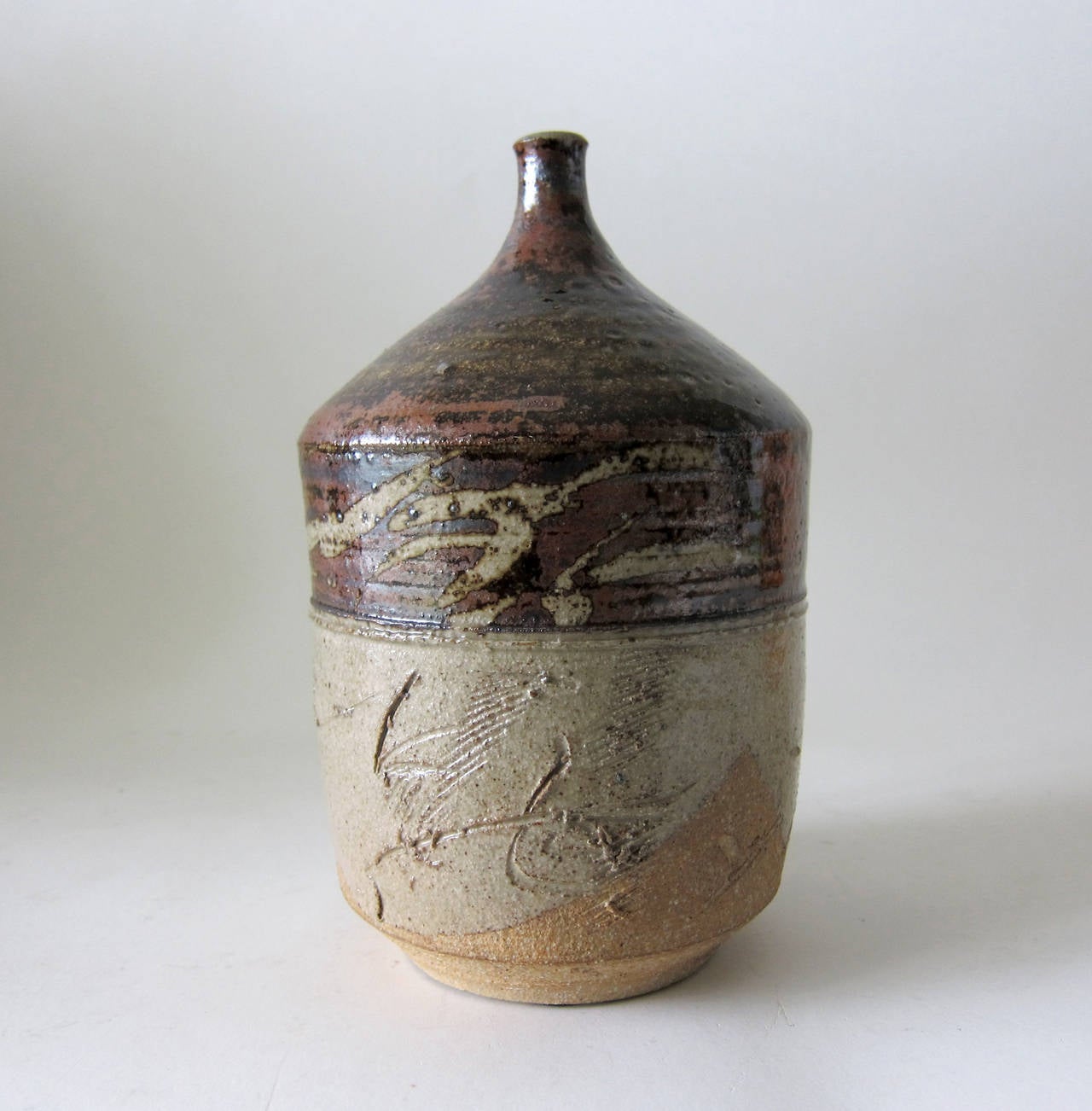 A spouted stoneware bottleneck vase with tenmoku glaze created by Paul Soldner of Claremont, California, circa 1960. Vase stands 9 1/8