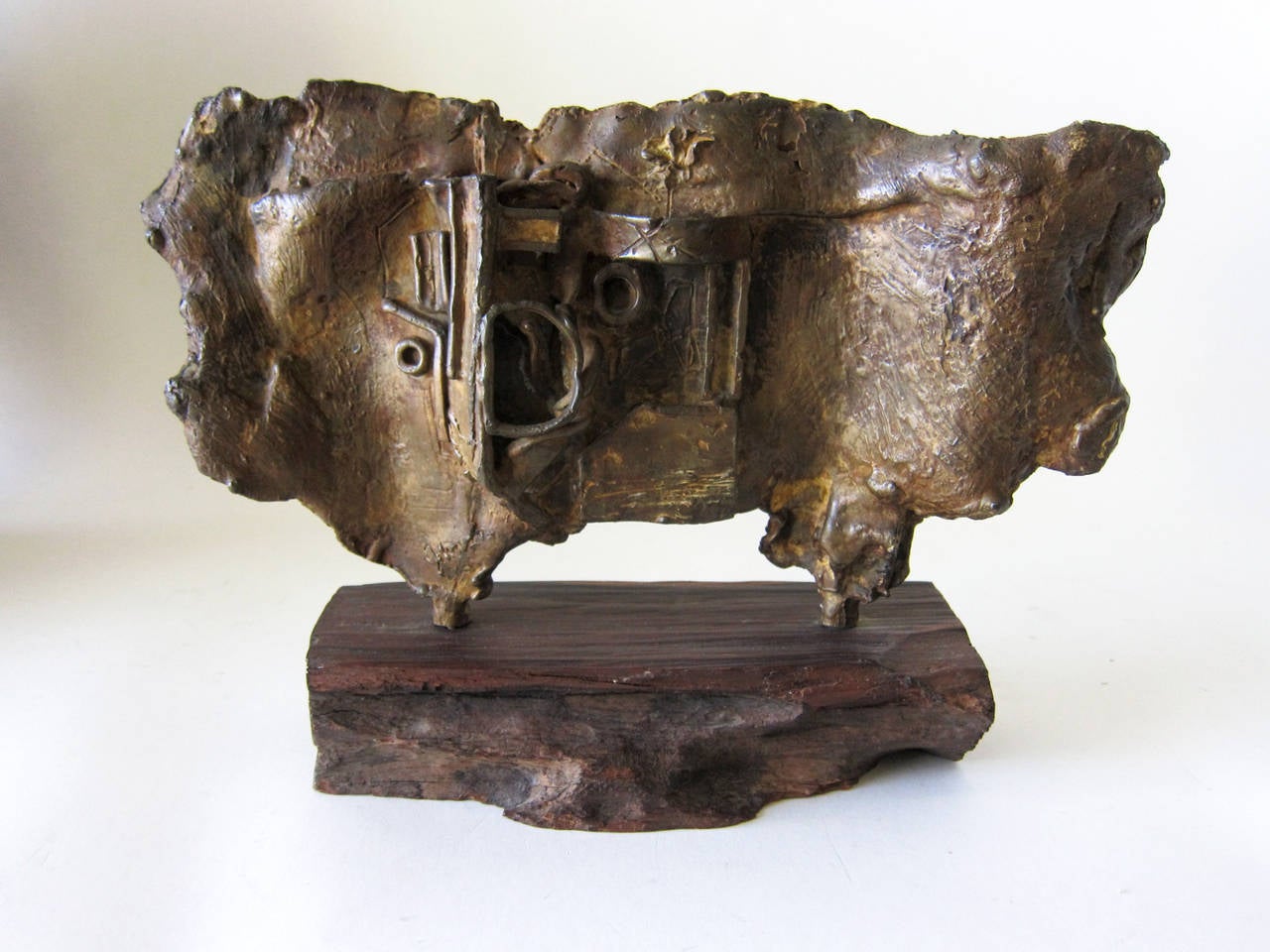 An abstract modernist bronze table sculpture on live edge base by Johnson. Sculpture measures 8.5