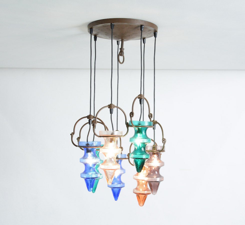 This colourful magnificent chandelier was designed by Nanny Still McKinney for Raak in the 1960s.
This is the largest version with seven metal pendants and moveable glass shades.The pendants can be lengthened for about 20 cm or more if we replace