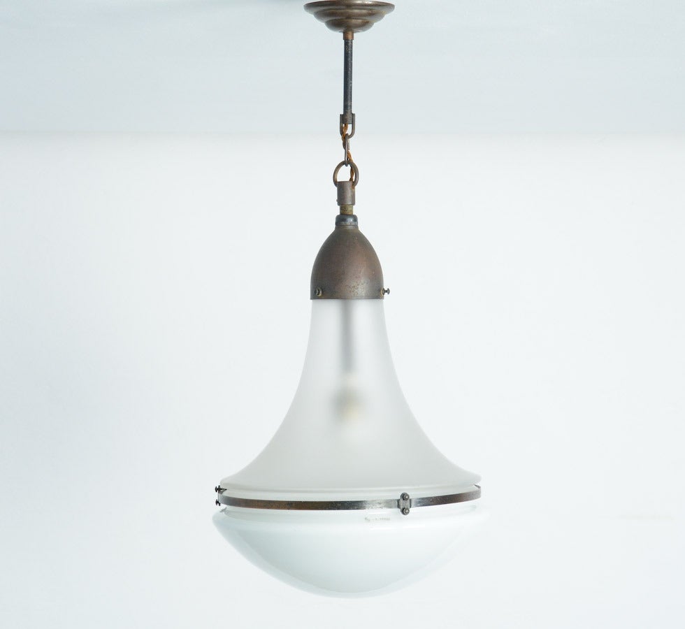 The Luzette hanging lamp was designed by Peter Behrens in 1908 for Siemens.
This lamp is complete original with a nice combination of a frosted glass upper shade and an opaline glass lower shade. The glass shades are numbered and marked with the