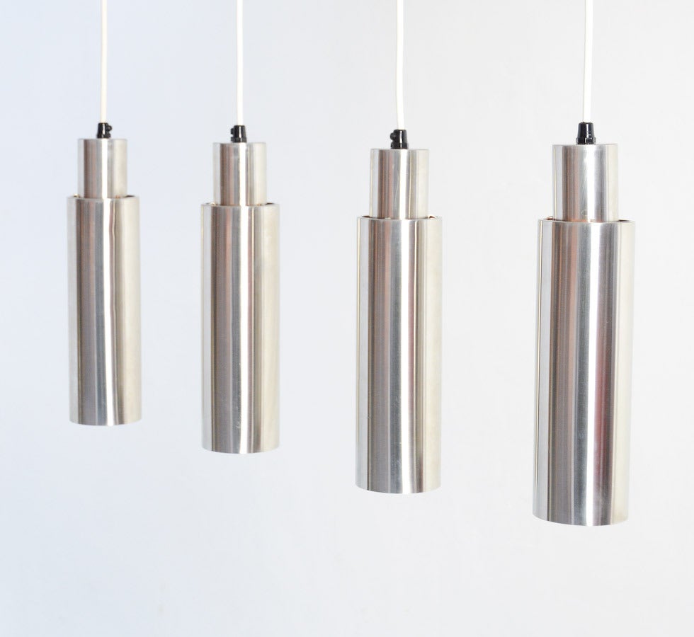 This nice set of 4 minimal hanging lamps were surely inspired by the design of Arne Jacobsen's Cylinda-line.
The cylindrical tubes are made of stainless steal/ inox. The lamps are all rewired.
They are beautiful in this set of 4, but also