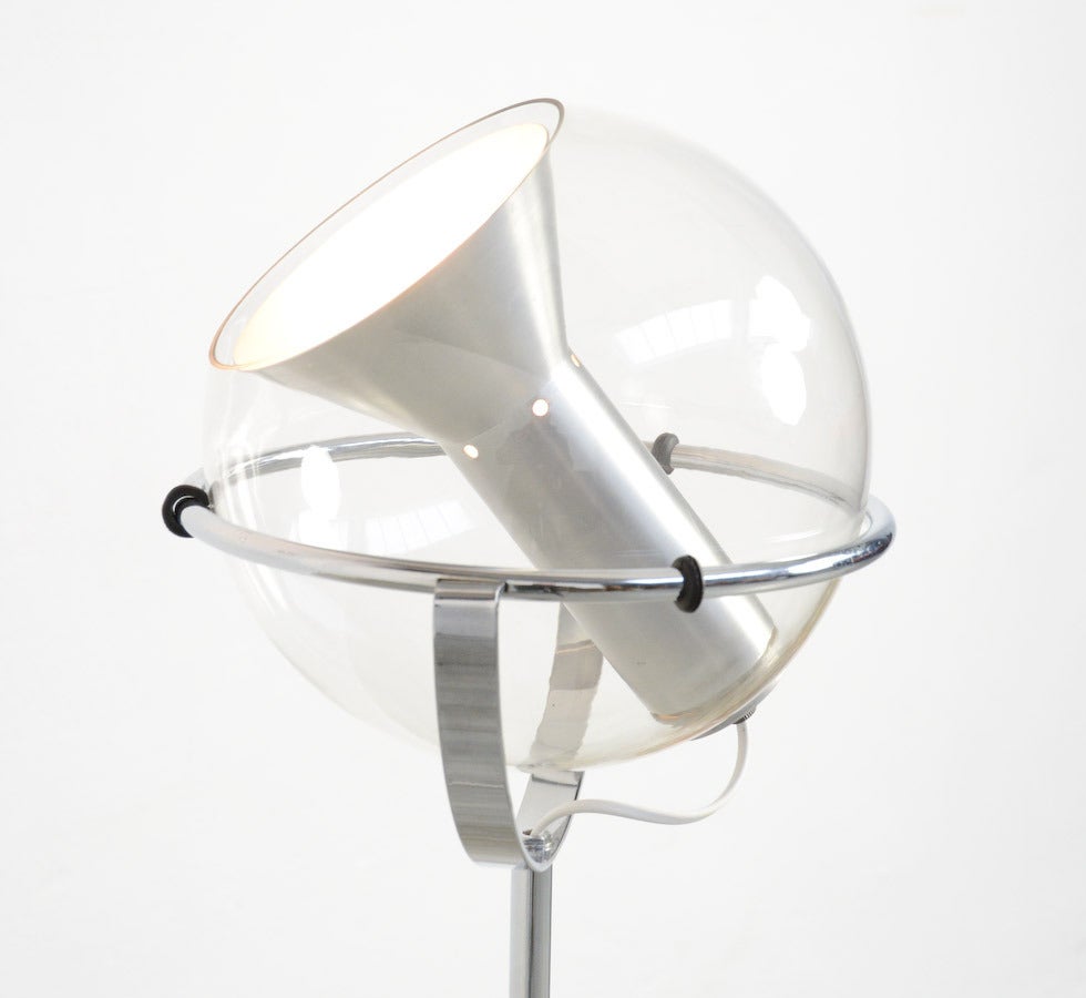 This chromium-plate steel floor lamp has a pivoting transparent glass globe on a height adjustable tripod foot. It is a design of Frank Ligtelijn for Raak Amsterdam in 1961.
The glass sphere can be lifted from the ring and turned in any direction.