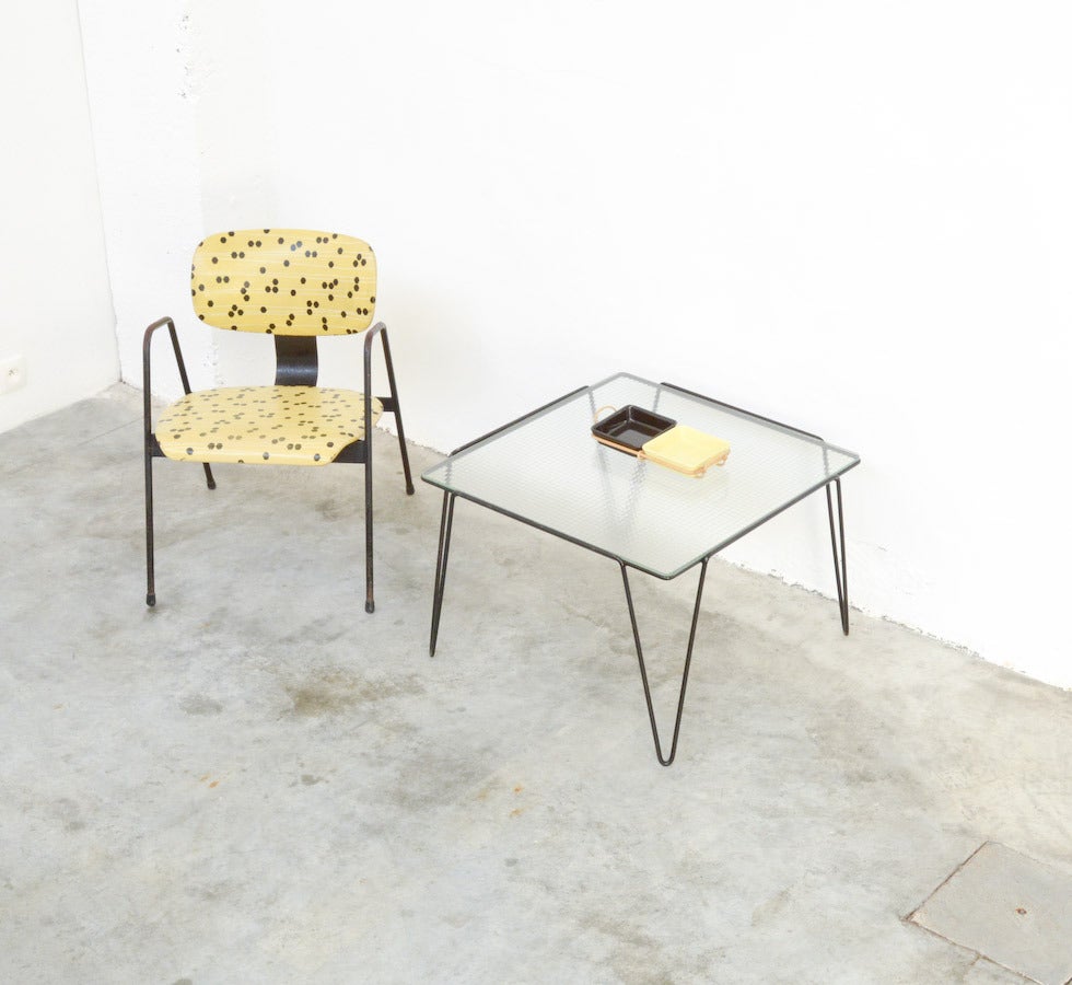 This rare side table was designed by Arnold Bueno de Mesquita for Goed Wonen in 1955.
The table has a square black lacquered metal base with 4 hairpin leggs. It is a nice example of 1950s design.
The glass table top is new.
The table is in very