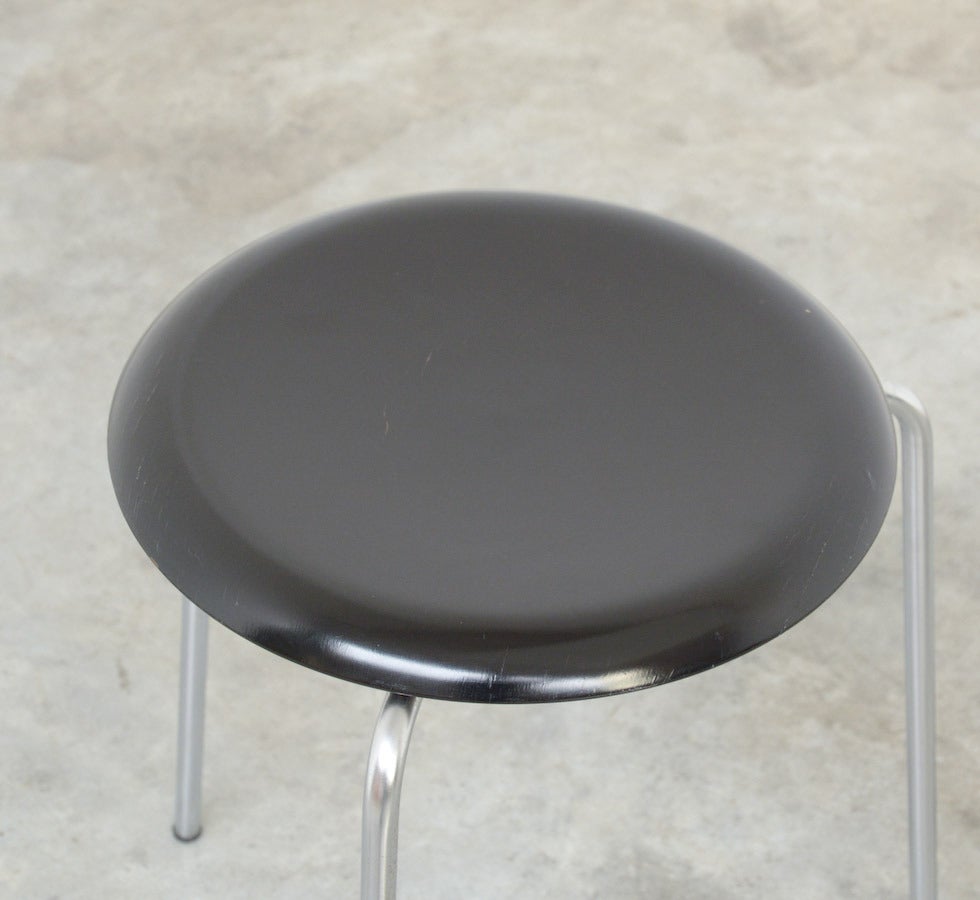 The Dot stool was designed by Arne Jacobsen for Fritz Hansen around 1950.
The three-legged dot stool was produced since 1954. In 1970 the stool was revitalized as we know it today, with four legs.
This Dot stool with three nickel-plated tubular