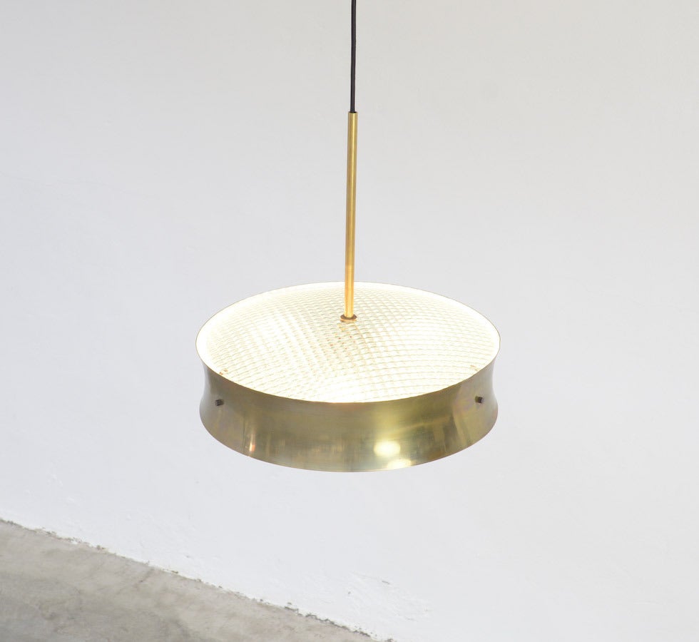 This exclusive and rare hanging lamp mod. 2091 was made by Fontana Arte in the 1964 (Catalog Fontana Arte n° 6, 1964). The curved brass shade is finished on the bottom and the top with a brute convex glass disc.
It is a special piece of the