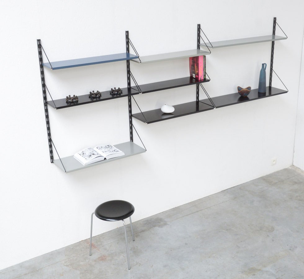 This metal wall unit was designed by Tjerk Reijenga for Pilastro in the 1950s.
It is a nice modular system. There is a lot of storage space with one blue, three grey and four black shelves. Let the pictures convince you.
This wall unit is in good