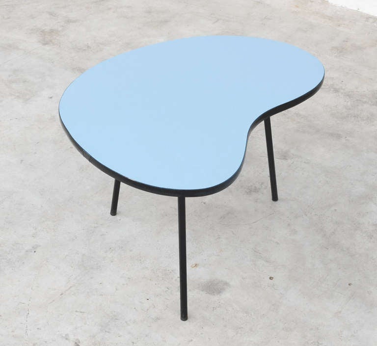 This beautiful kidney shaped side table was designed by Pierre Guariche for Trefac/ Meurop Belgium in the fifties.
The blue formica top is fixed on a black metal tripod base.
It has the same kidney shaped top as the side table of the Prefacto