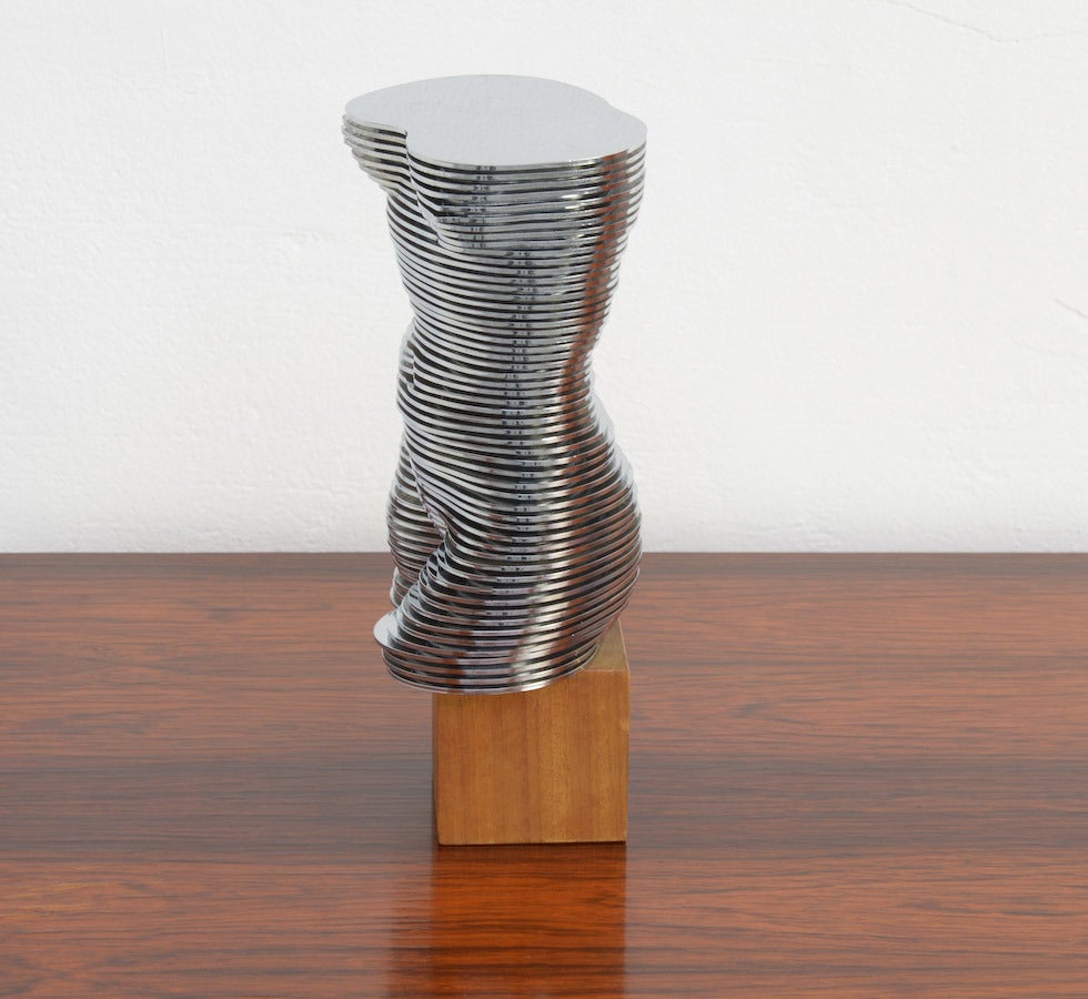 Questa scultura di torso di donna mobile EVA è composta da dischi di diverse dimensioni che ruotano su un asse centrale in metallo. Ogni disco può essere spostato individualmente per formare una scultura completamente astratta. La scultura è firmata
