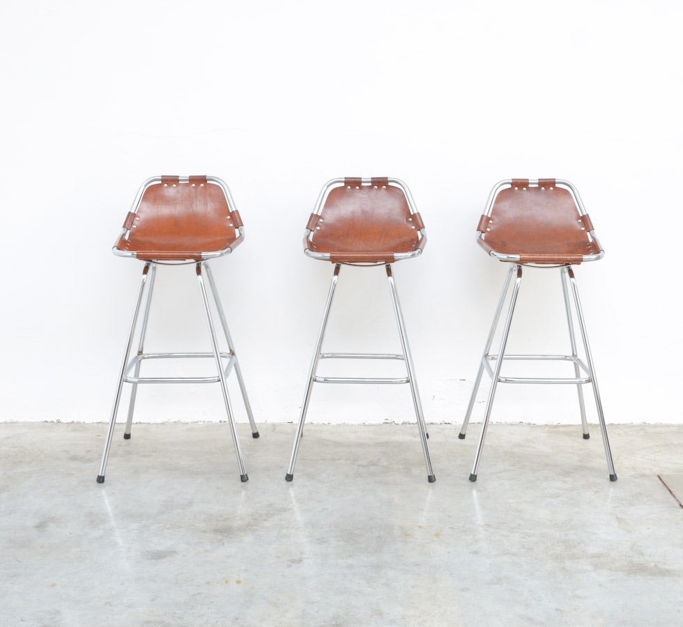 These bar stools were designed by Charlotte Perriand for Ski Resort ‘Les Arcs’ in France in the 1960s.
They have a tubular chromium-plated frame and a thick cognac leather seat with chromium-plated buttons. The leather has a nice patina. The stools