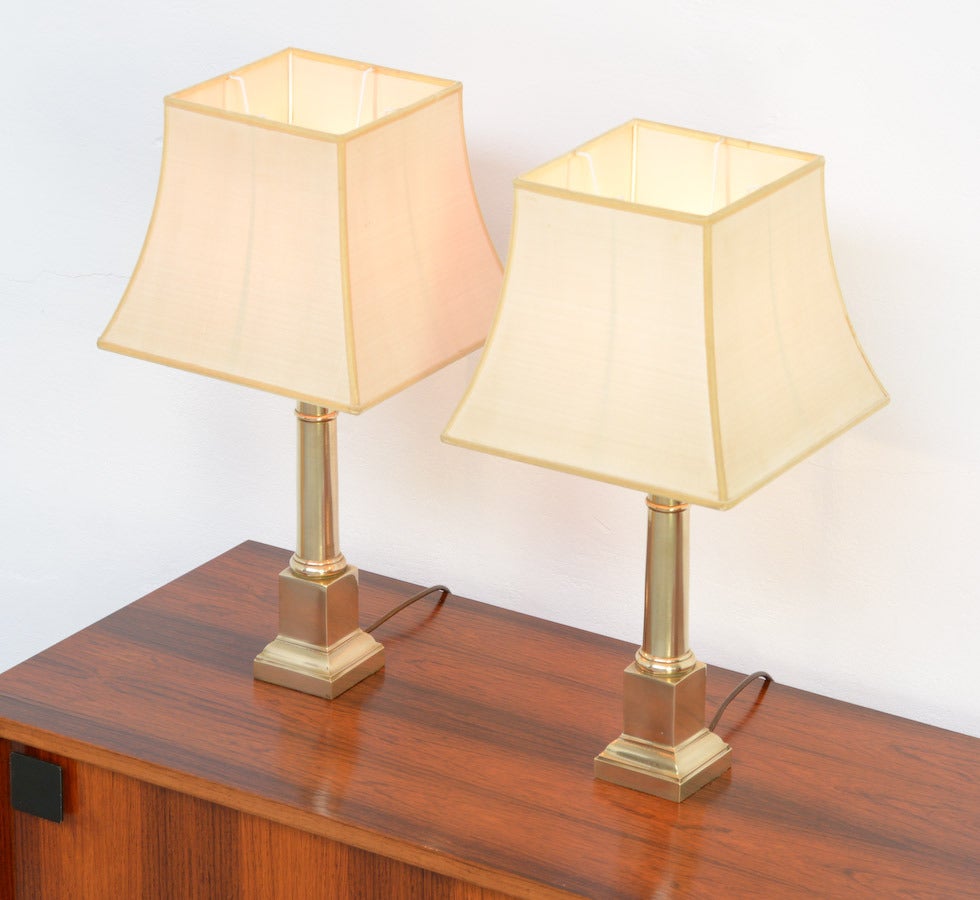 These beautiful brass Tuscan column table lamps are a design of the 1970s.
They have a classical look.
Both lamps are in very good vintage condition although the original silk lamp-shades have some spots. 
We have a pair of larger lamps in the