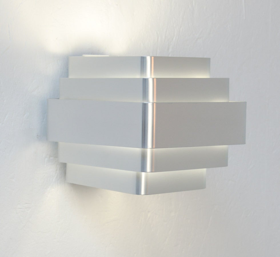 This beautiful wall lamp was designed by the Belgian interior designer Jules Wabbes in 1968.
The 5 anodized aluminium strips diffuse the light.
This lamp is a special edition with a low energy lamp of the 1980s.
This lamp is in perfect vintage