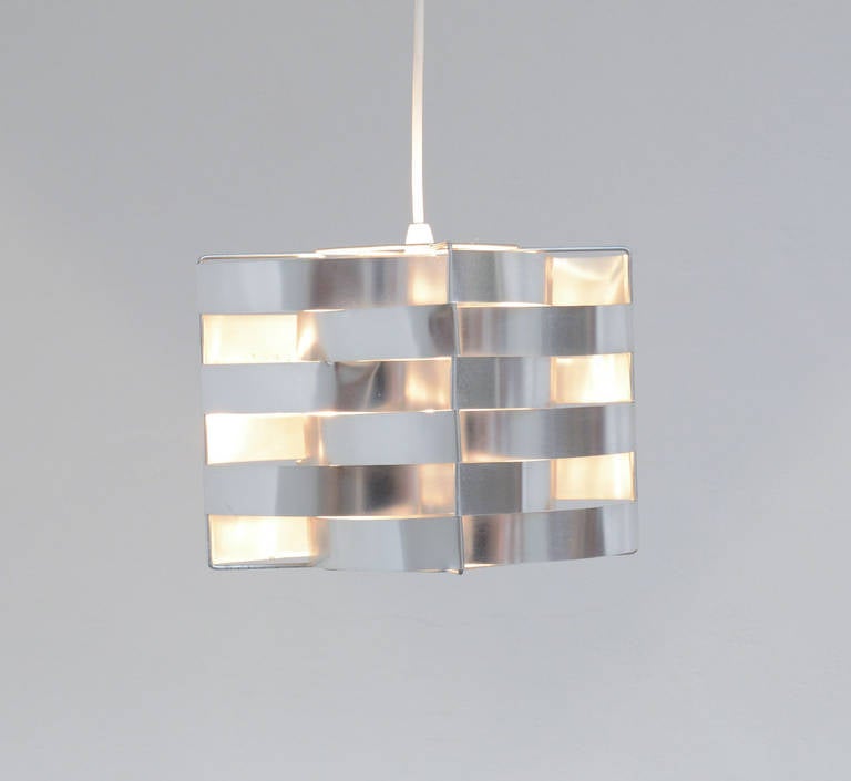 This fantastic cube pendant lamp was designed by the sculptor Max Sauze for the Max Sauze Studio in the 1970s.
The wired frame holds many aluminium bent strips creating a cube structure. It creates a warm and amazing light effect.
The lamp is in