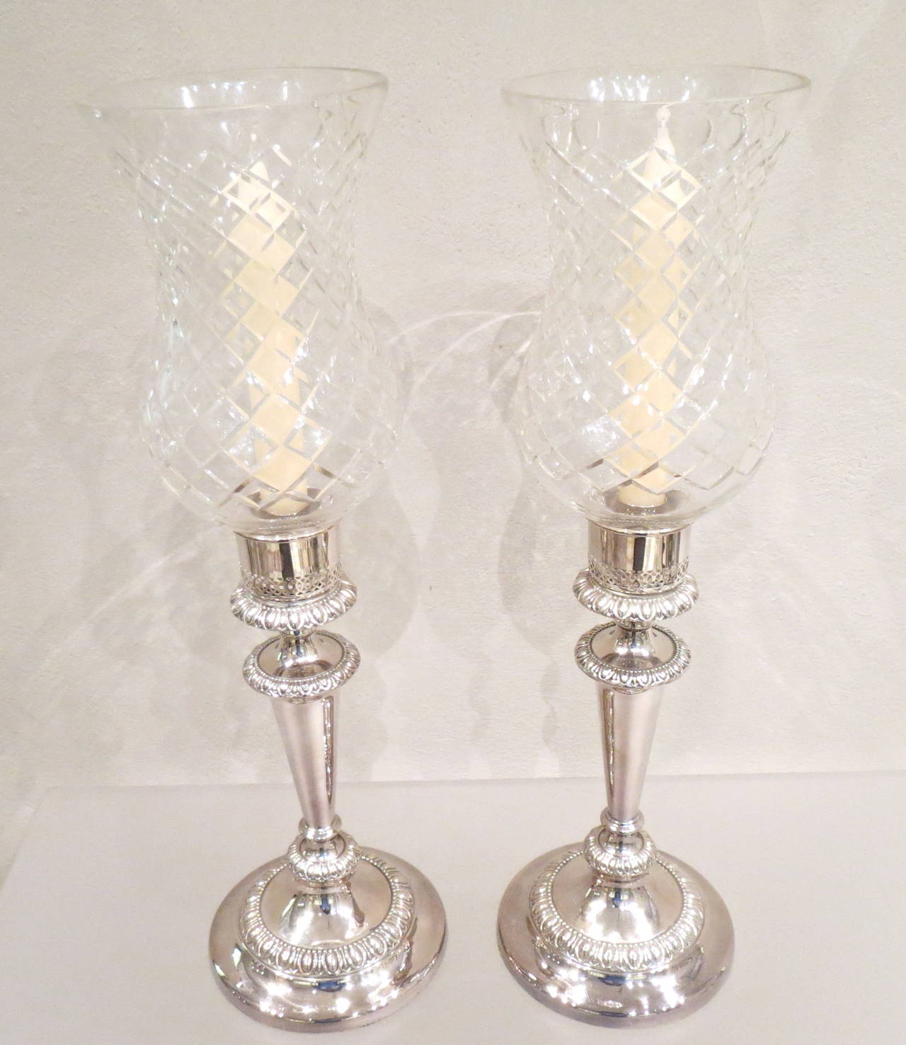 Sheffield plate pair of candlesticks with cut-glass storm shades, England, 1820-1830.