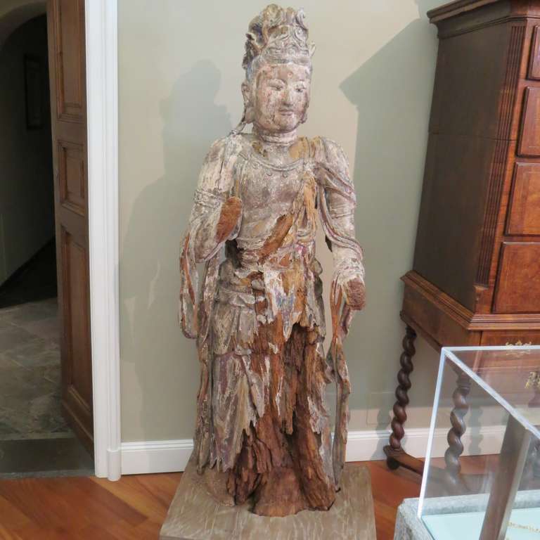 Early Ming standing carved wood Bodhisattva Avalokiteśvara (Guanyin), China 1368-1644. This massive Bodhisattva Guanyin is depicted here in the form of a very detailed, painted-wood statue. The paint has faded with time, leaving behind the