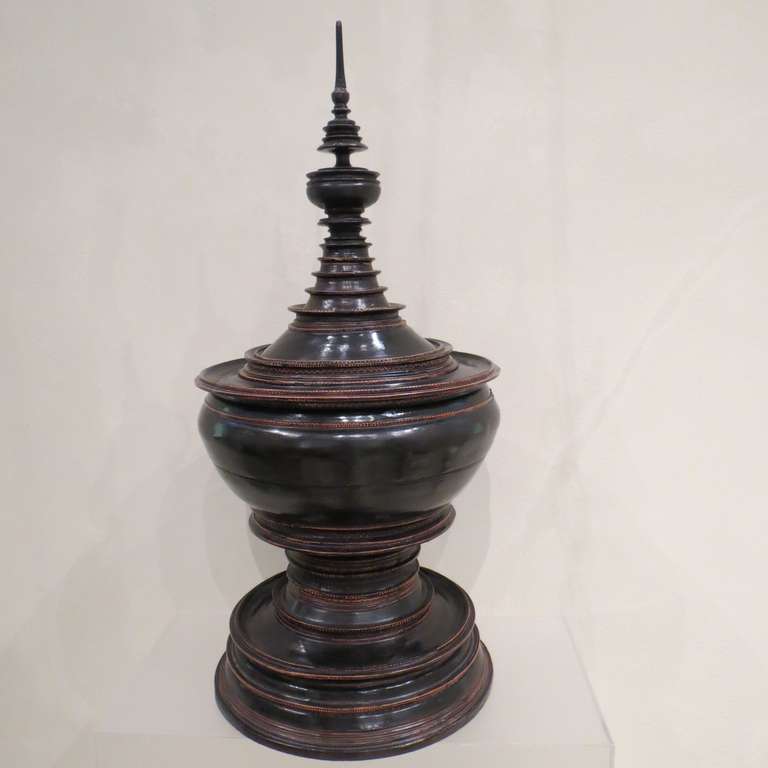 Late 19th Century Burmese black lacquer special ceremonial offering vessel. Detailed spire form the top of the lid, stepped curved ring molded bowl above round base. Multiple layers of red  and black lacquer adorn this pagoda shaped ceremonial