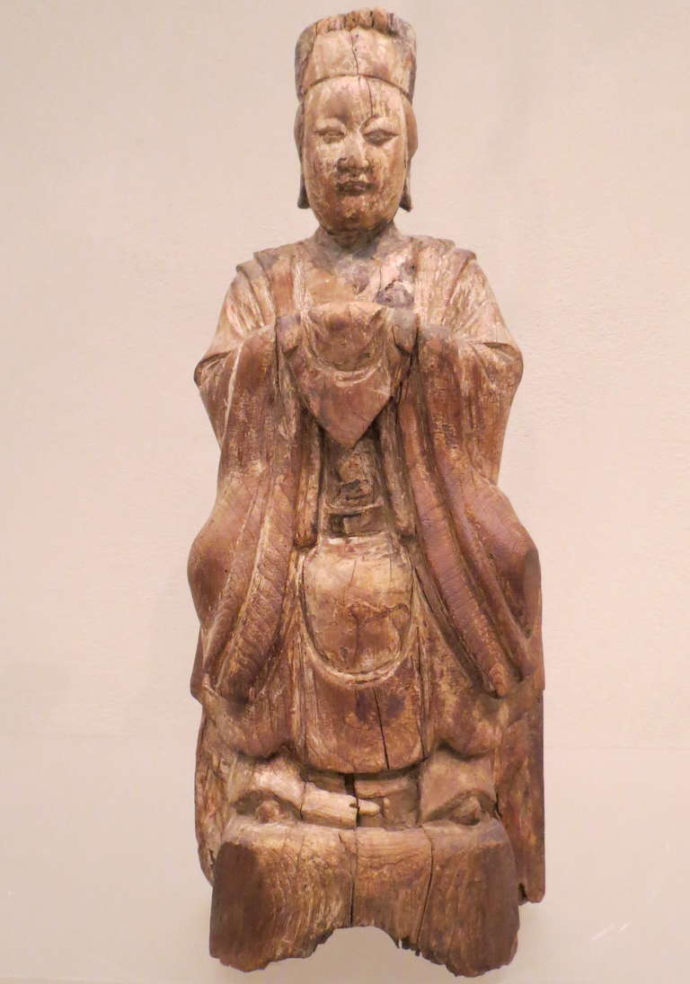 The Queen Mother of the West is carved in a seated position with her hands held before her chest holding a 