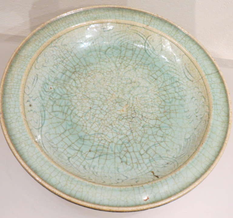 Antique Southeast Asian, possibly Thai or Vietnamese, celadon ceramic charger with a crackled glaze.