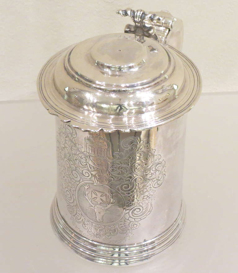 Large and impressive early Georgian Irish sterling silver lidded tankard, slightly tapering cylindrical form,raised on a skirted foot , flat top hinged cover with a decorative scroll thumb piece, hollow scroll handle terminating in a semicircle.The