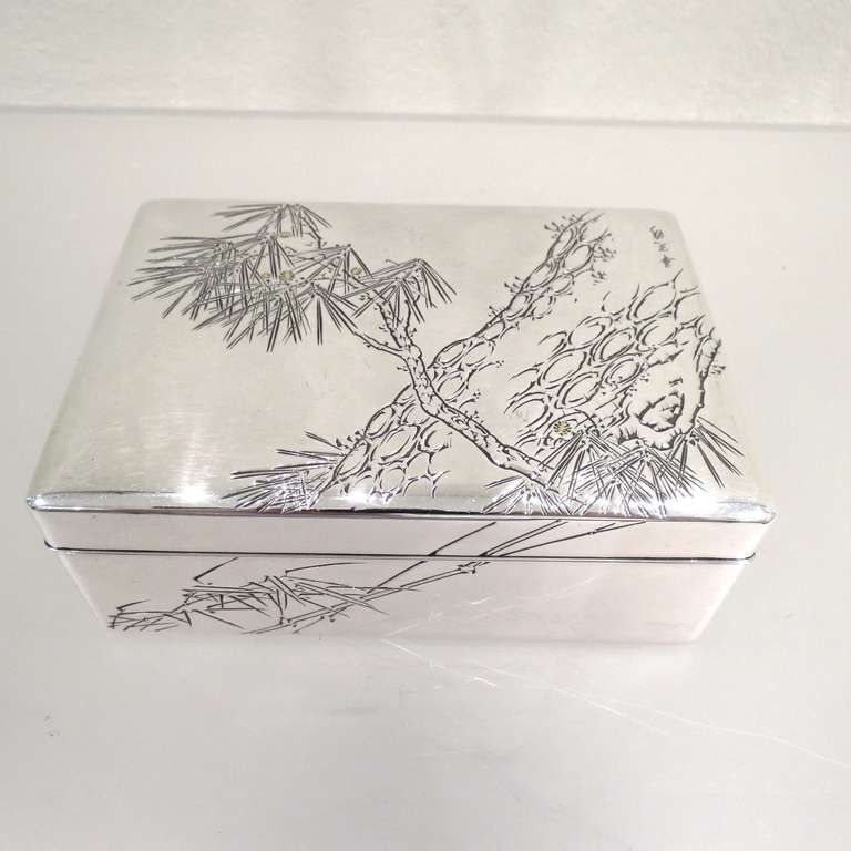 Japanese 999 fine silver framed box having a chased pine and gold cones design to cover. Has dark wood interior and bottom, circa mid 20th century, post war period. Measures: Width 14 cm., depth 10 cm., height 5cm., weight 440 gr. with wood.