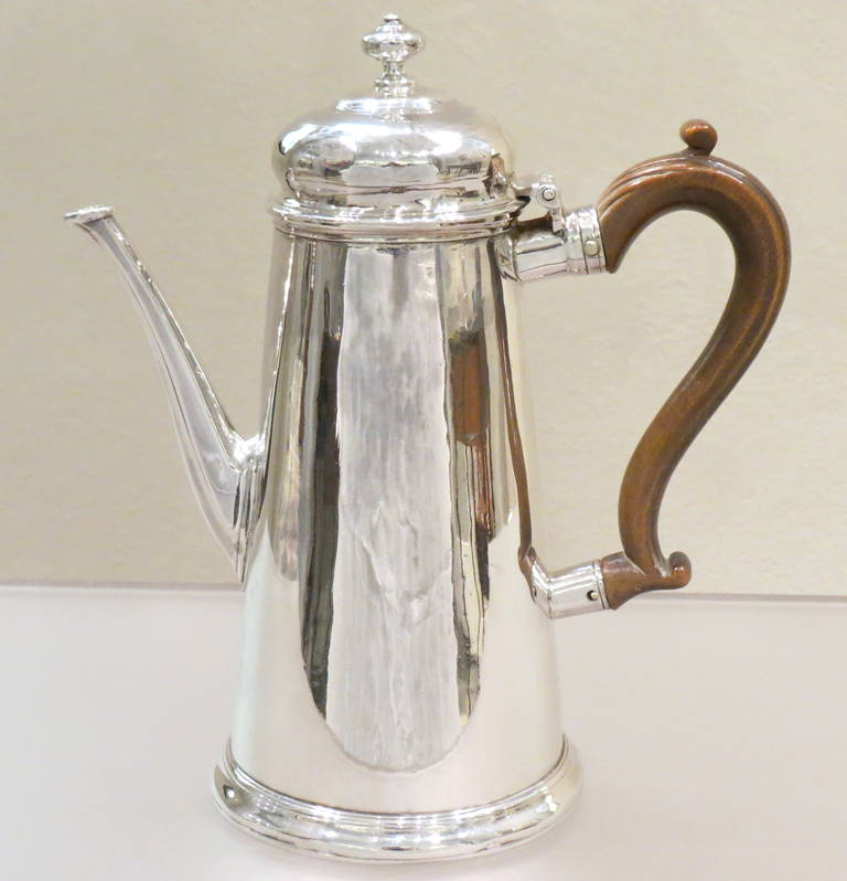 Antique Georgian sterling silver George II coffee pot, having a plain round body with straight tapering sides, a hinged cushion style lid with finial, an octagonal panelled spout, a boxwood scroll handle, and all sitting on a collet foot. Made by