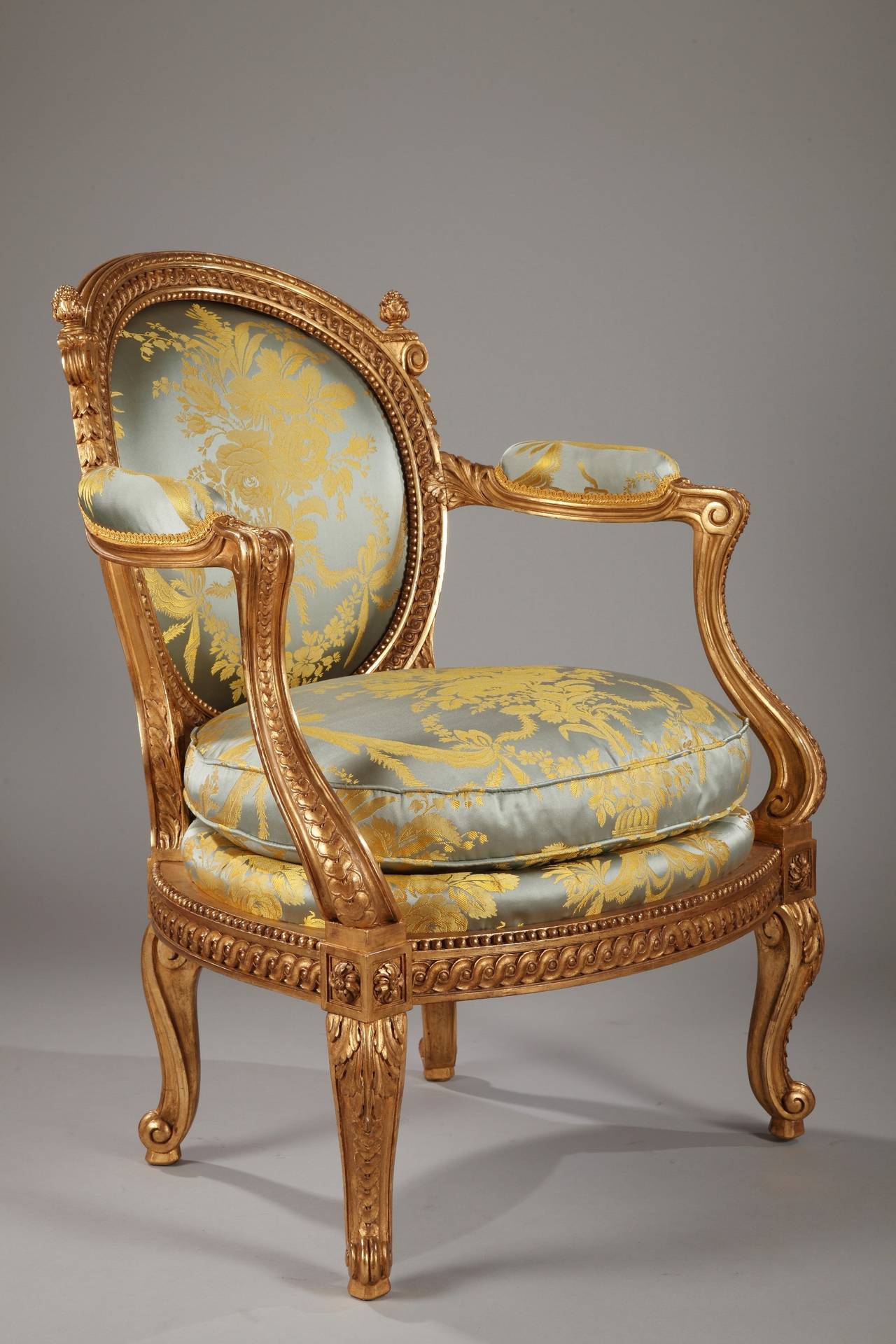 Rare sculpted and gilded wood armchair with a medallion back. Richly adorned with friezes of interlacings, beads and piastres, completed with rosettes and acanthus leaves. Standing on console feet. 
Its reduced dimensions allow affirming that this