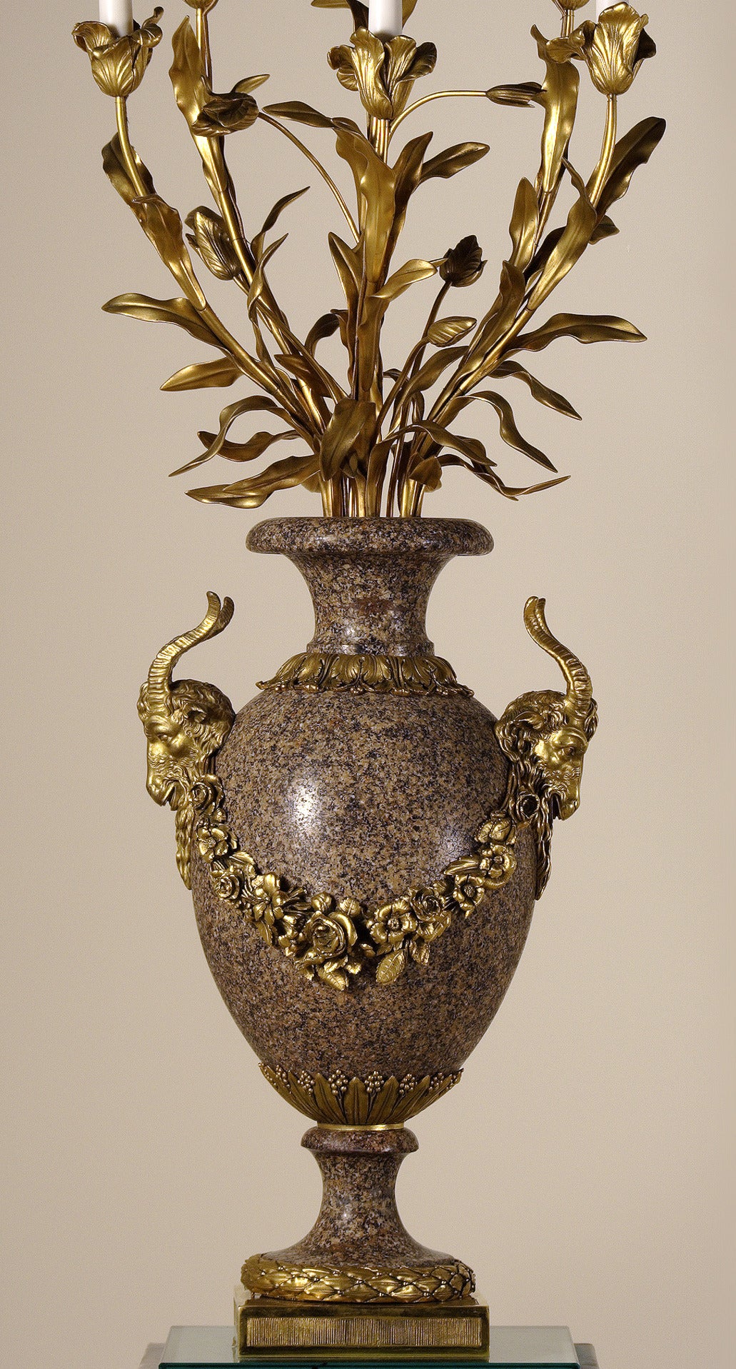 Beautiful granite and ormolu pair of candelabra vases. Six light arms imitating a floral composition emerging from the vases. Granite vases ornamented with ram heads joined by a flower garland. Resting on a circular base adorned with an ormolu