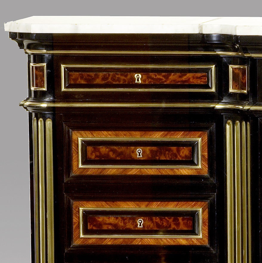Blackened wood and brass inlaid with loupe d'orme and kingwood parquetry. Three frieze drawers and six lateral drawers. Central panel door with flower marquetry and ivory inlaid on a  blackened wood ground. White marble top. 