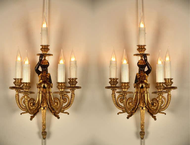 Pair of Neoclassical gilt and patinated bronze wall sconces 

France
Circa 1880
Height : 44 cm (17 1/3 in.); Width : 29 cm (11 1/2 in.) ; Depth : 20 cm (7 3/4 in.)

Pair of dual patina five lights Neoclassical wall sconces, figuring a