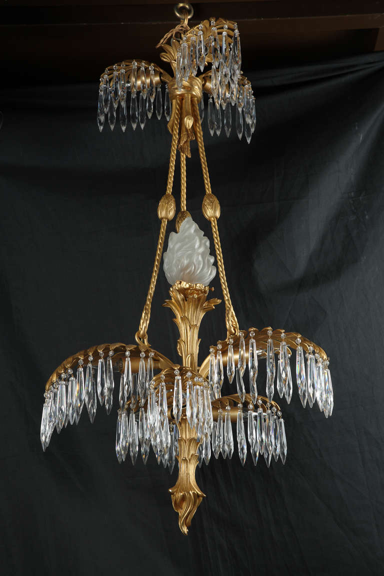 A very fine palm chandelier. France, circa 1890.<br />
Height : 85 cm (33 1/2 in.) ; Diameter : 45 cm (17 3/4 in.)<br />
<br />
Superb gilt-bronze chandelier with a palm tree-shaped shaft issuing elegant leaves from which hang cut-crystal pendants