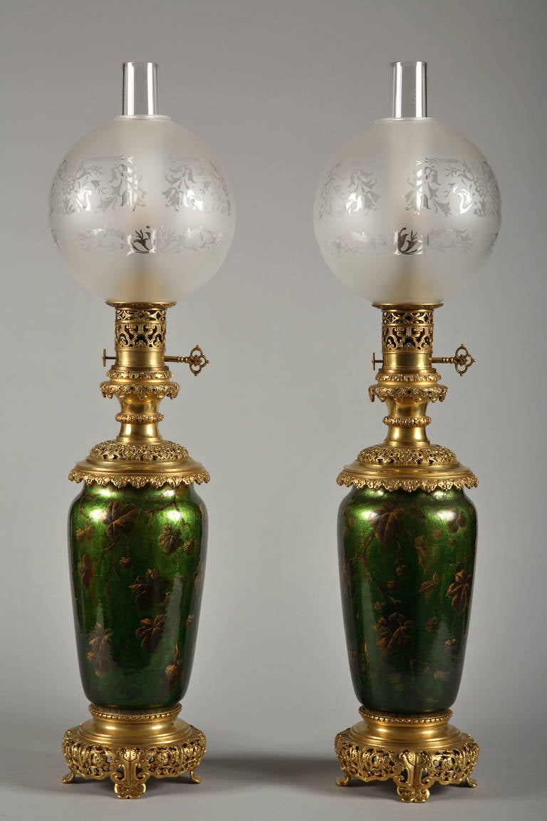 Pair of Napoleon III period lamps.

France,
circa 1880.
Height : 77 cm (30 1/3 in.) ; Diameter : 16,5 cm (6 1/2 in.).

A pair of gilt bronze mounted eglomized glass lamps. The vase body decorated on green moired background with gilded-brown