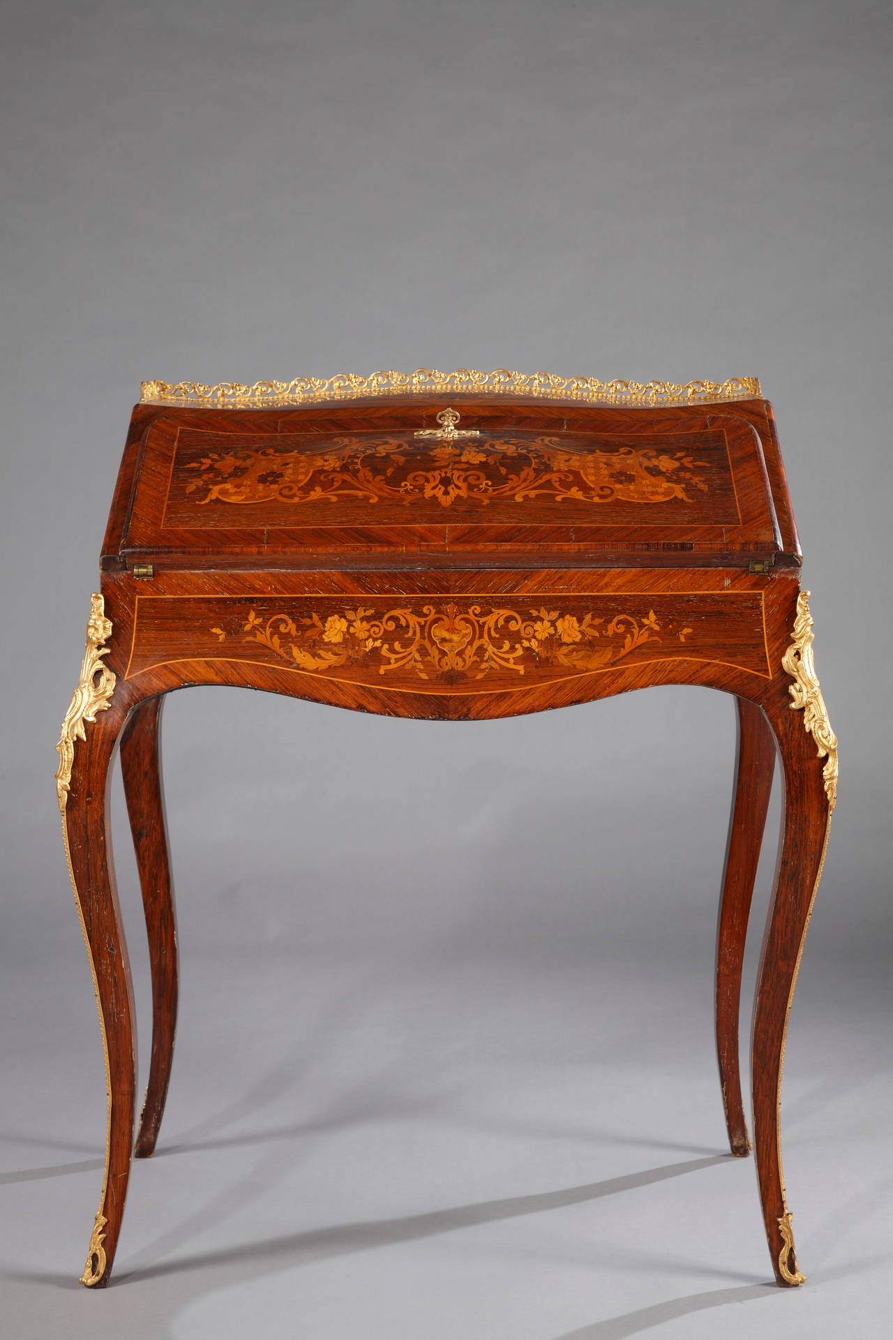 A Louis XV style lady desk.

France,
circa 1880.
Height: 92 cm (36 1/4 in.); Length: 79 cm (31 in.); Depth: 50 cm (19 2/3 in).

An elegant Louis XV style lady’s writing desk of serpentine shape, made in rose –and satinwood veneer and adorned