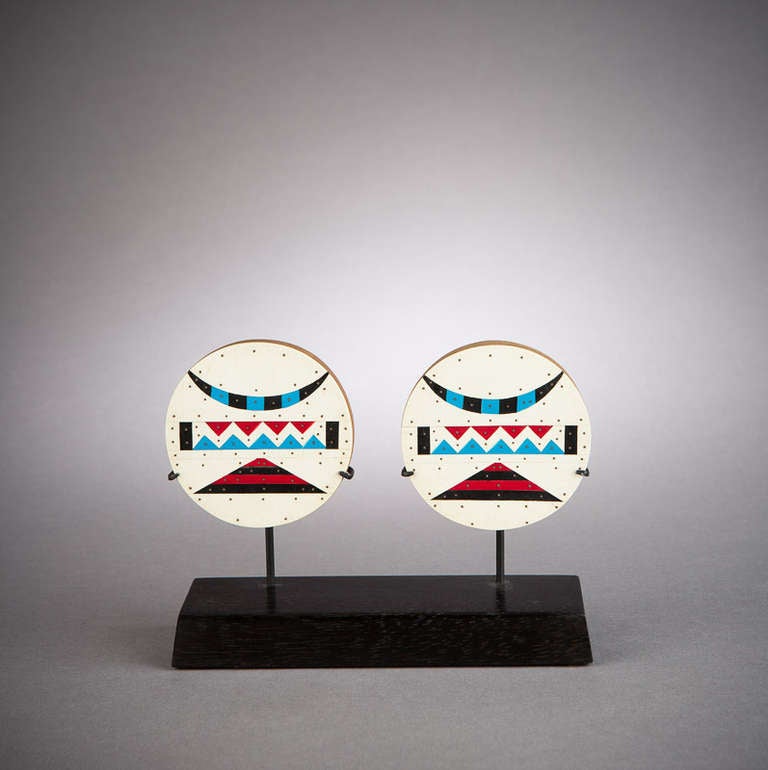 A colorful and beautifully designed pair of ear plugs. At an early age, a Zulu child's earlobes were pierced and gradually stretched to allow for larger and larger ear plugs to be worn.   This pair dates to the middle of the 20th century. They were